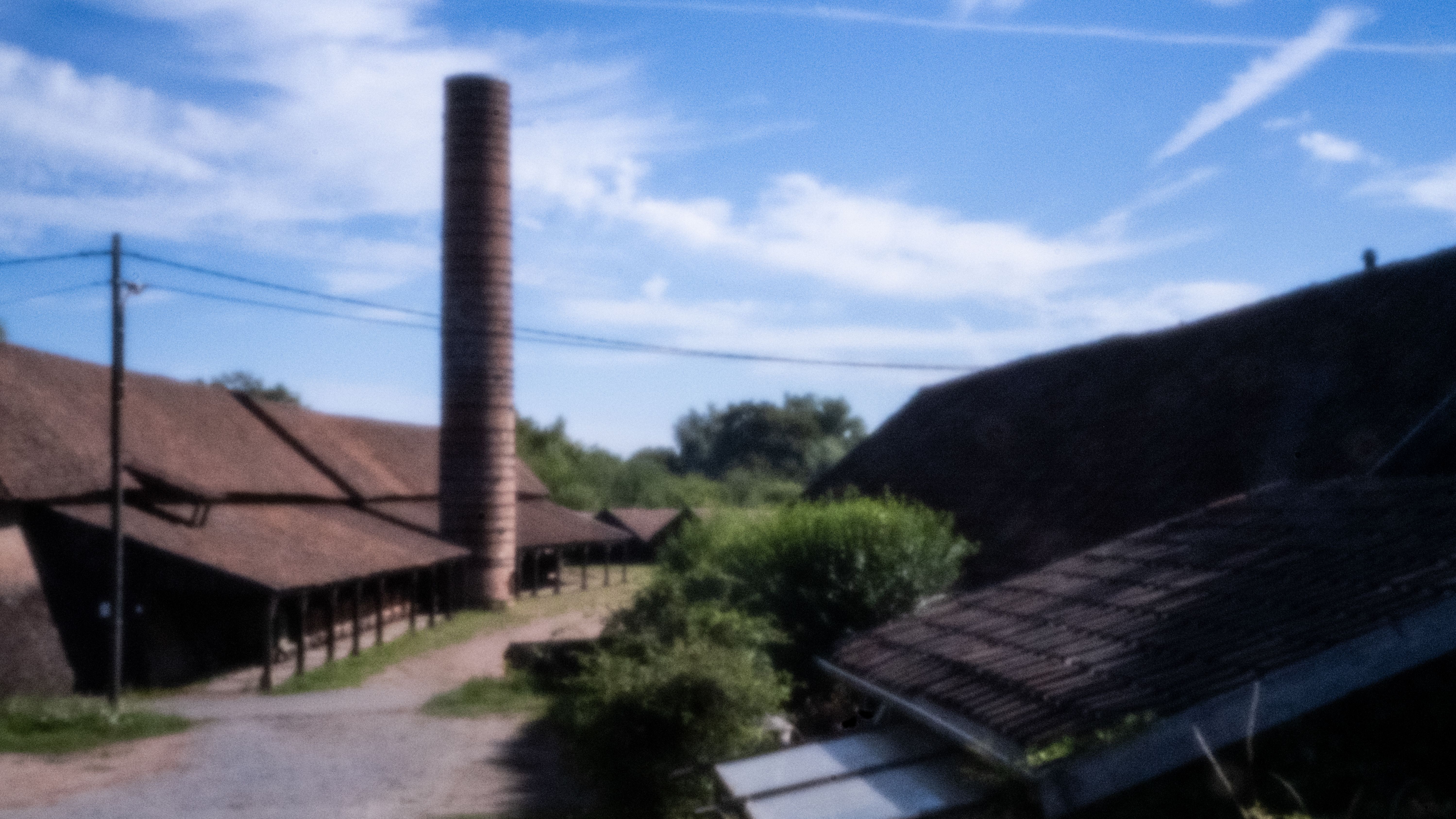 Fabrieksschoorsteen en daken van de oude steenbakkerij in Noeveren
