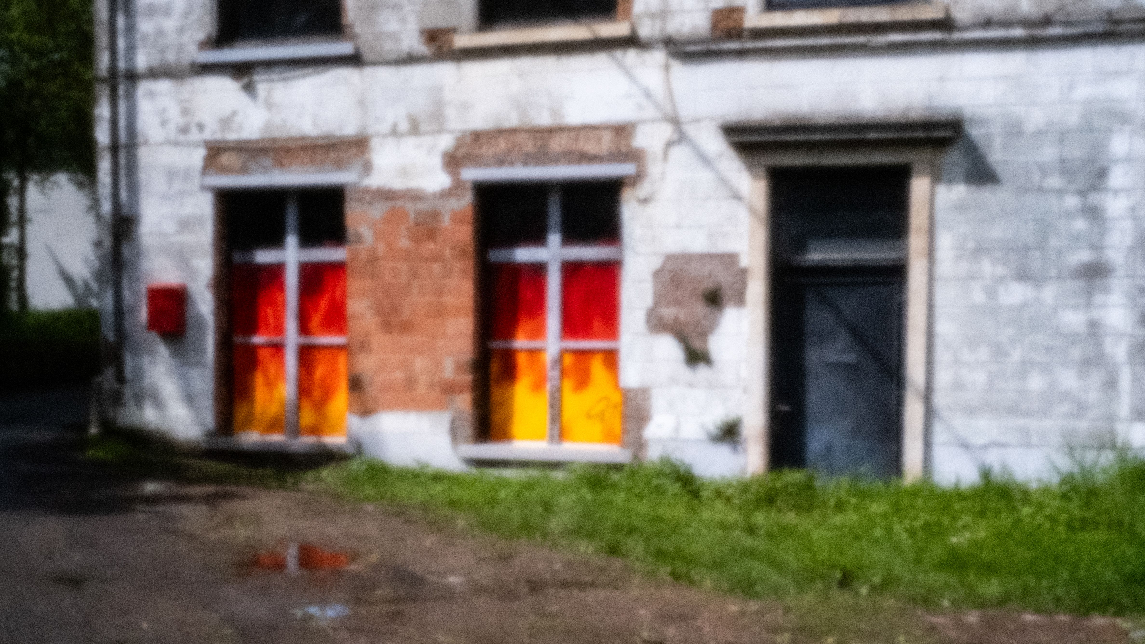 Vervallen woonhuis met dichtgeschilderde deuren in oranje en rood