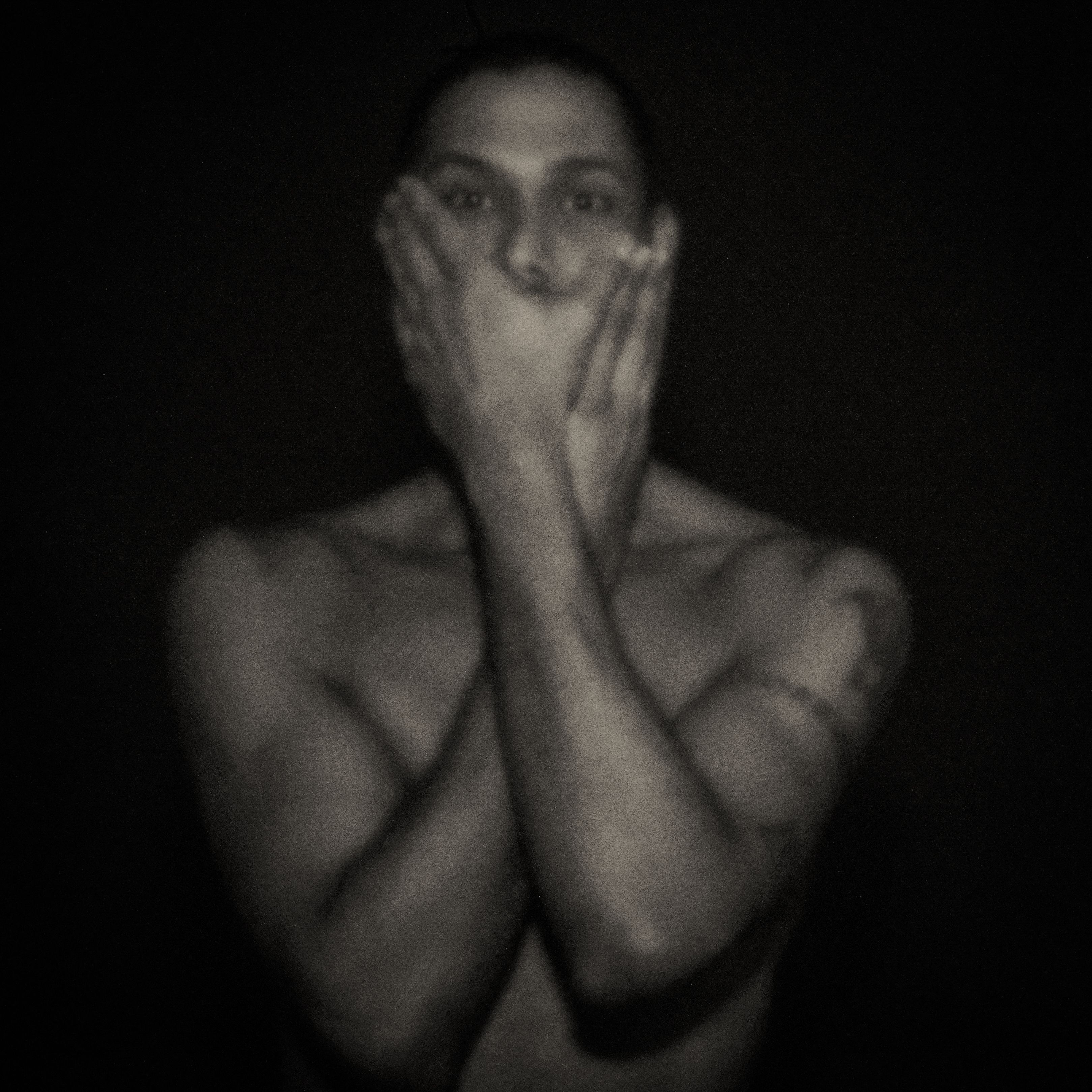 Pinhole-portret van een man die beide handen voor zijn mond houdt