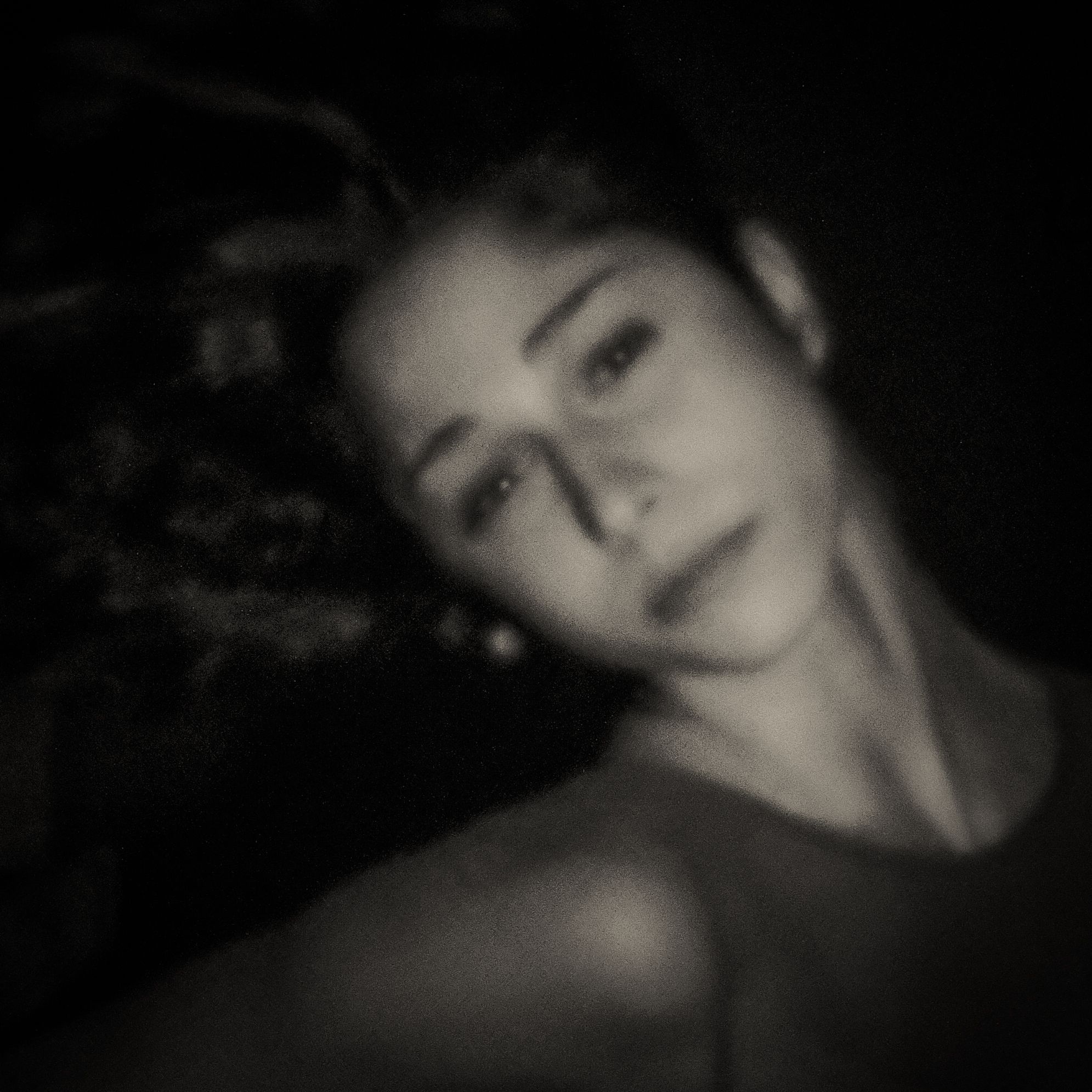 Pinhole-portret van een liggende vrouw, haar hoofd rustend op haar arm