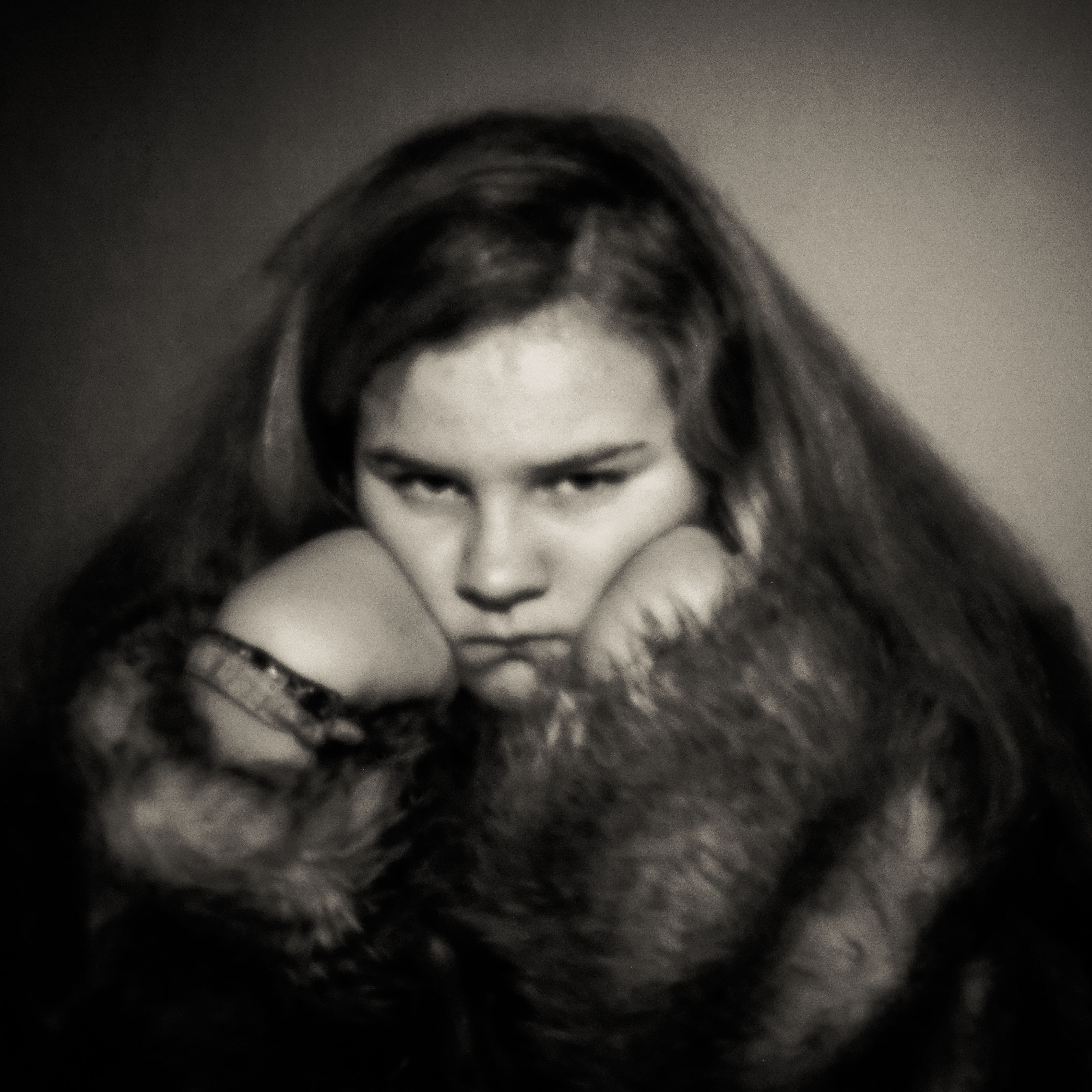 Pinhole-portret van een meisje in een bontkraag, kin op de handen