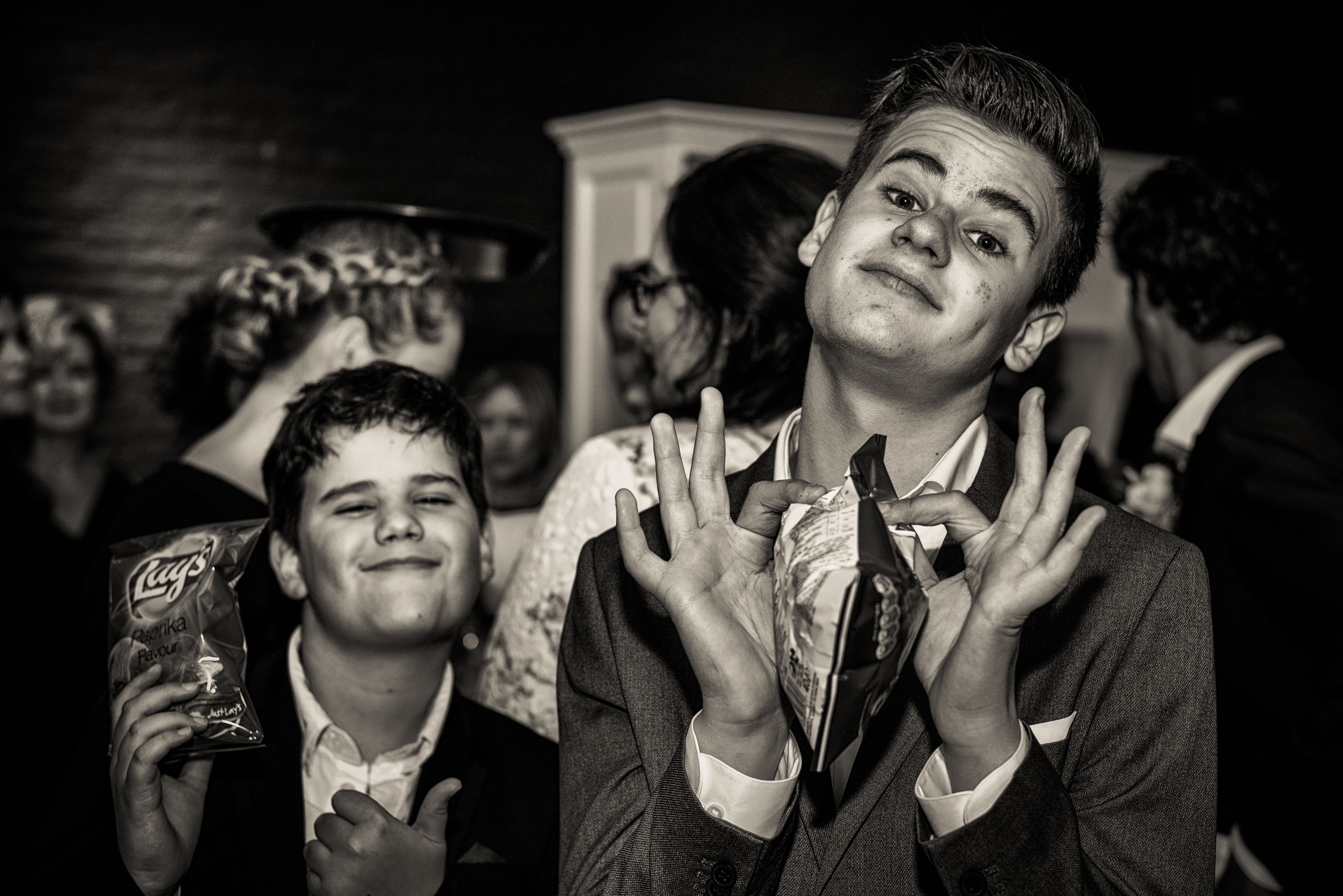 Twee jongens poseren uitgelaten op een feest, zwart-wit