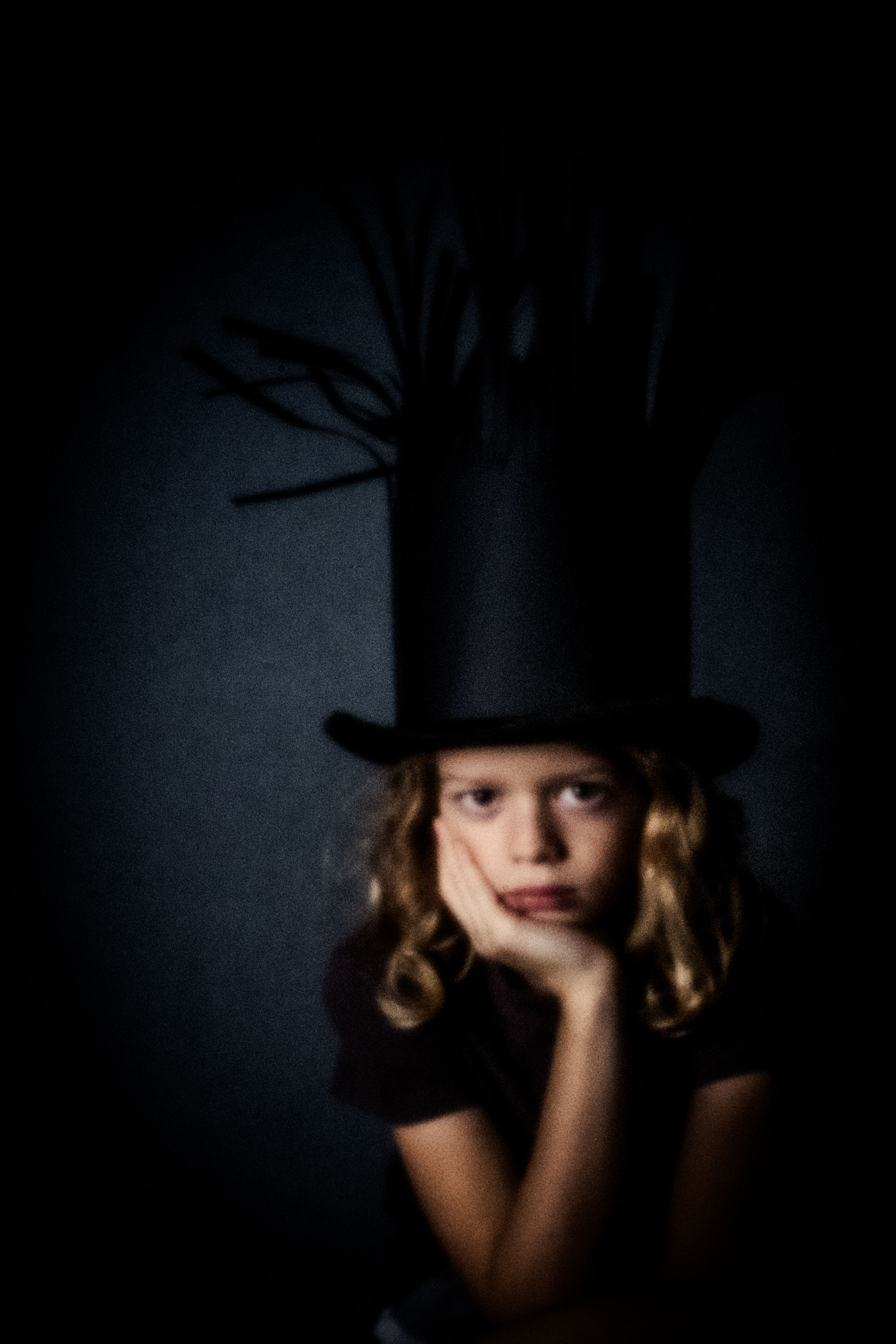 Pinhole-portret van een meisje met een hoge zwarte hoed met takken